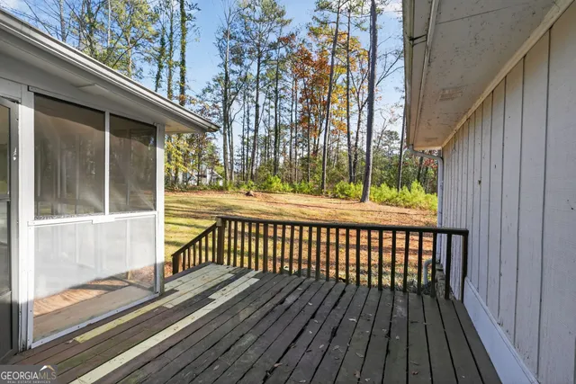 a view of a wooden balcony with a floor to ceiling window