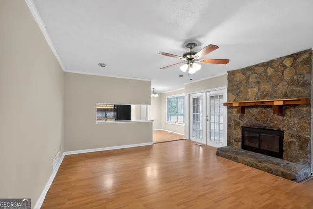 an empty room with fireplace fan and windows