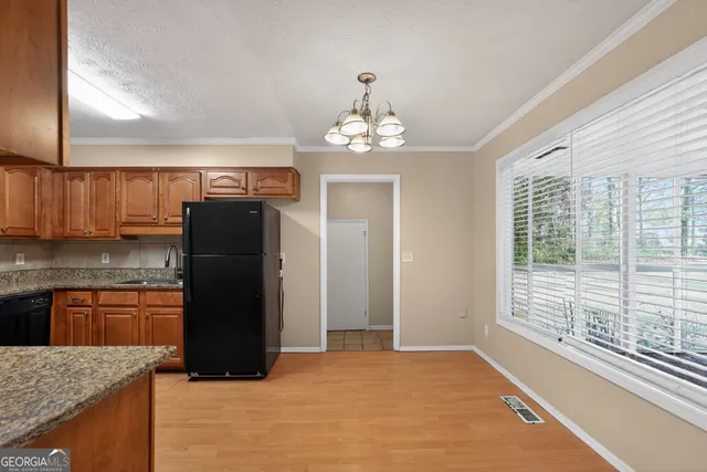 a kitchen with stainless steel appliances granite countertop a refrigerator and a sink