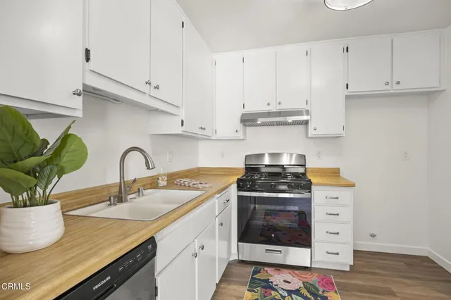 a kitchen with granite countertop a stove sink and cabinets
