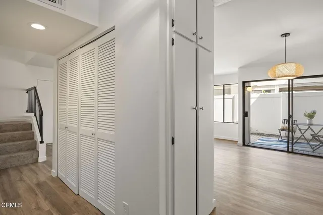 a view of a hallway with wooden floor and stairs