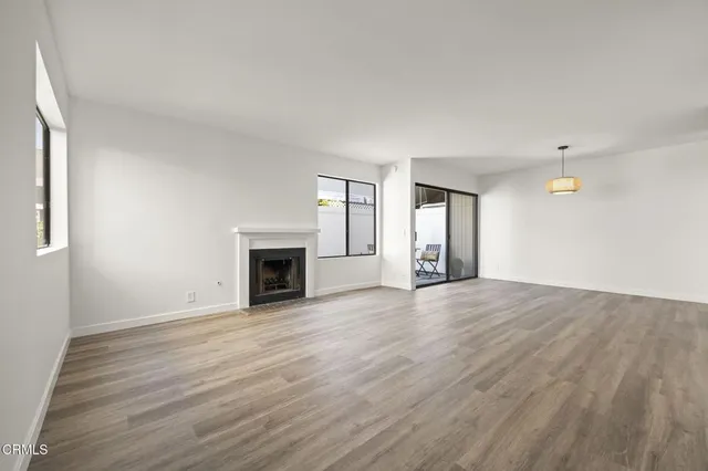 an empty room with wooden floor and fireplace