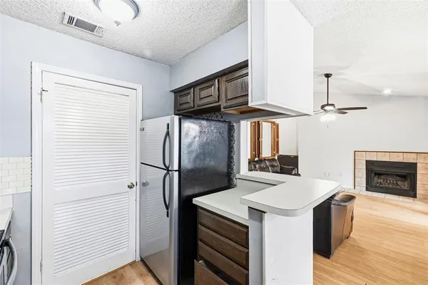 a kitchen with stainless steel appliances a stove a refrigerator and a fireplace