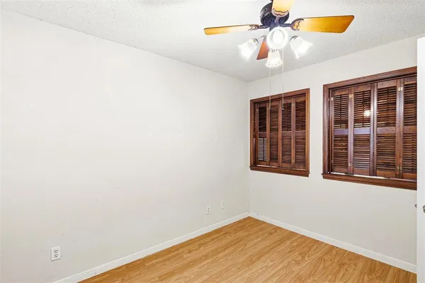 a view of an empty room with a window and a ceiling fan