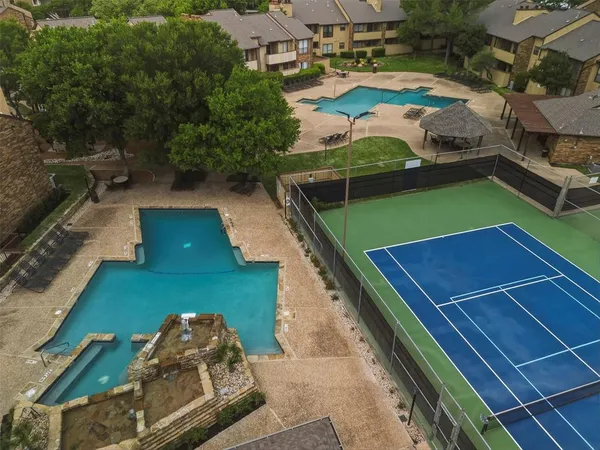 a view of a tennis ground with large trees
