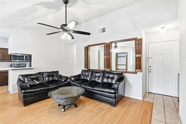 a living room with furniture and a ceiling fan
