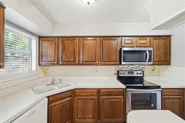 a kitchen with a sink stove and microwave