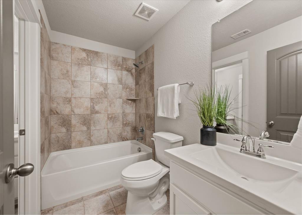 2521 Boot Jack Road Fort Worth, TX 76177 - Photo 34 of 40 a bathroom with a sink a toilet a mirror a bathtub and shower