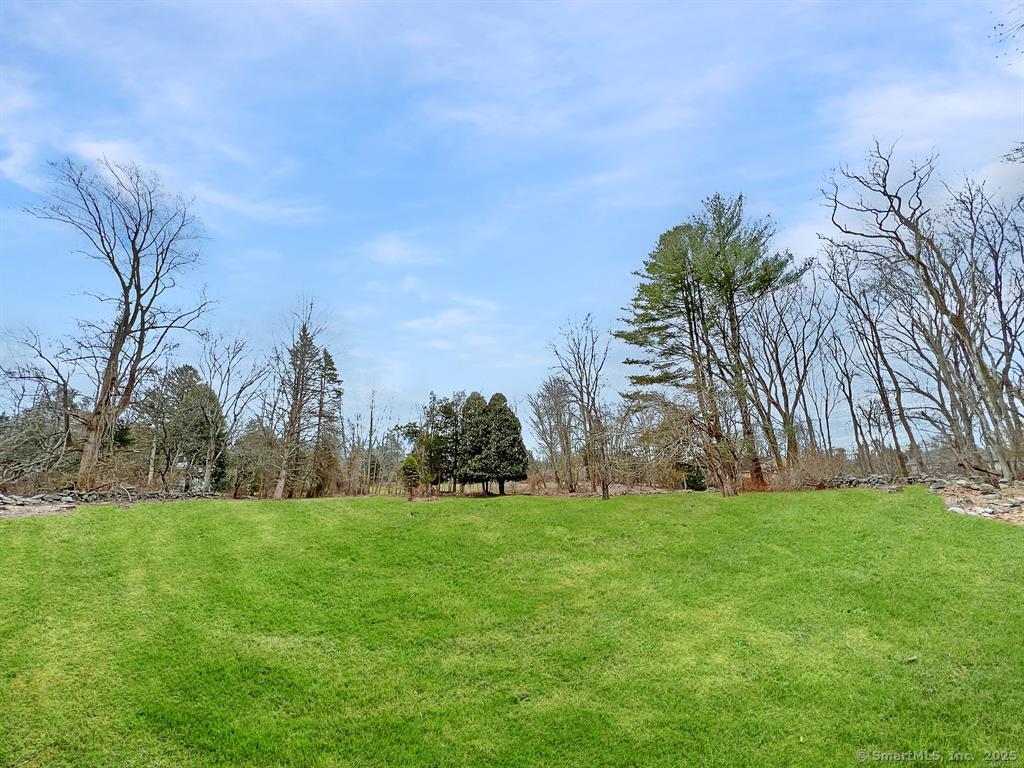 180 Catamount Road Fairfield, CT 06824 - Photo 2 of 3 a view of a building in front of a big yard with plants and large trees