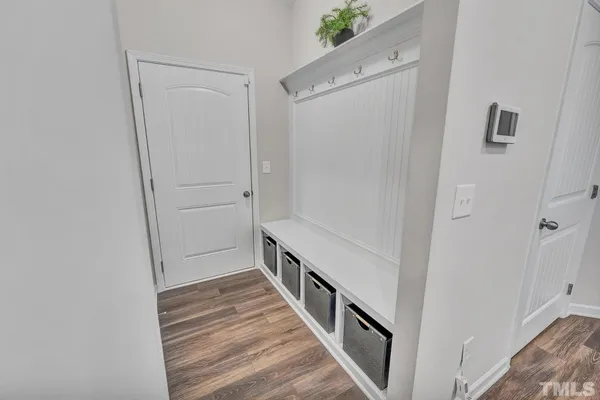 a view of a hallway with wooden floor and entryway