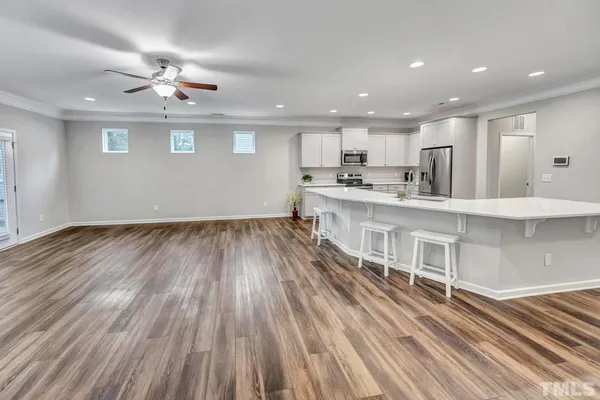 a large white kitchen with wooden floors and a fireplace