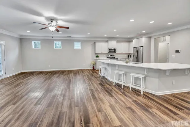 a large white kitchen with wooden floors and a fireplace