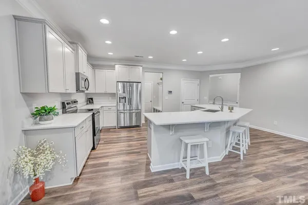 a large kitchen with kitchen island a sink table and chairs