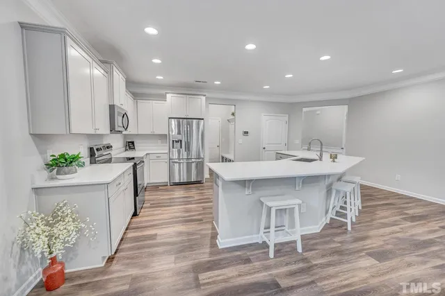 a large kitchen with kitchen island a sink table and chairs