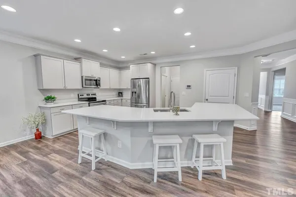 a kitchen with kitchen island cabinets and chairs in it