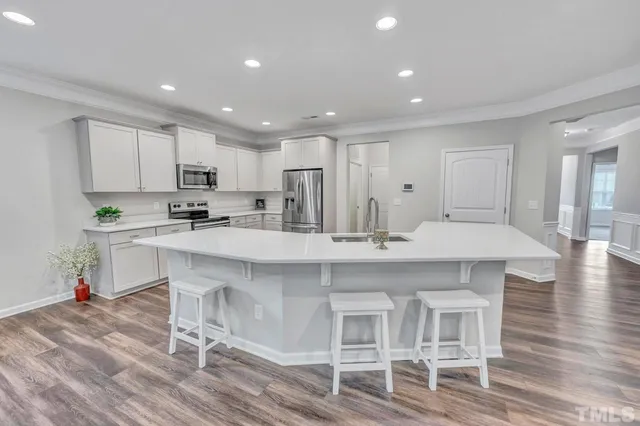 a kitchen with kitchen island cabinets and chairs in it