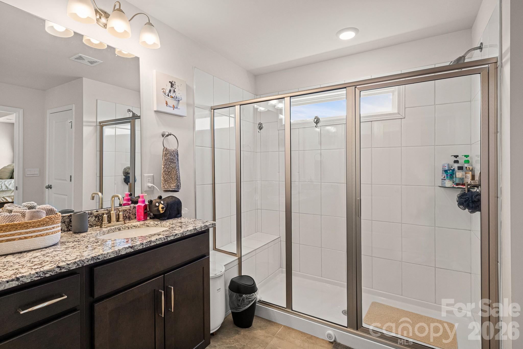199 Fox Cove Road Hendersonville, NC 28792 - Photo 26 of 48 a bathroom with a granite countertop sink a mirror and a shower
