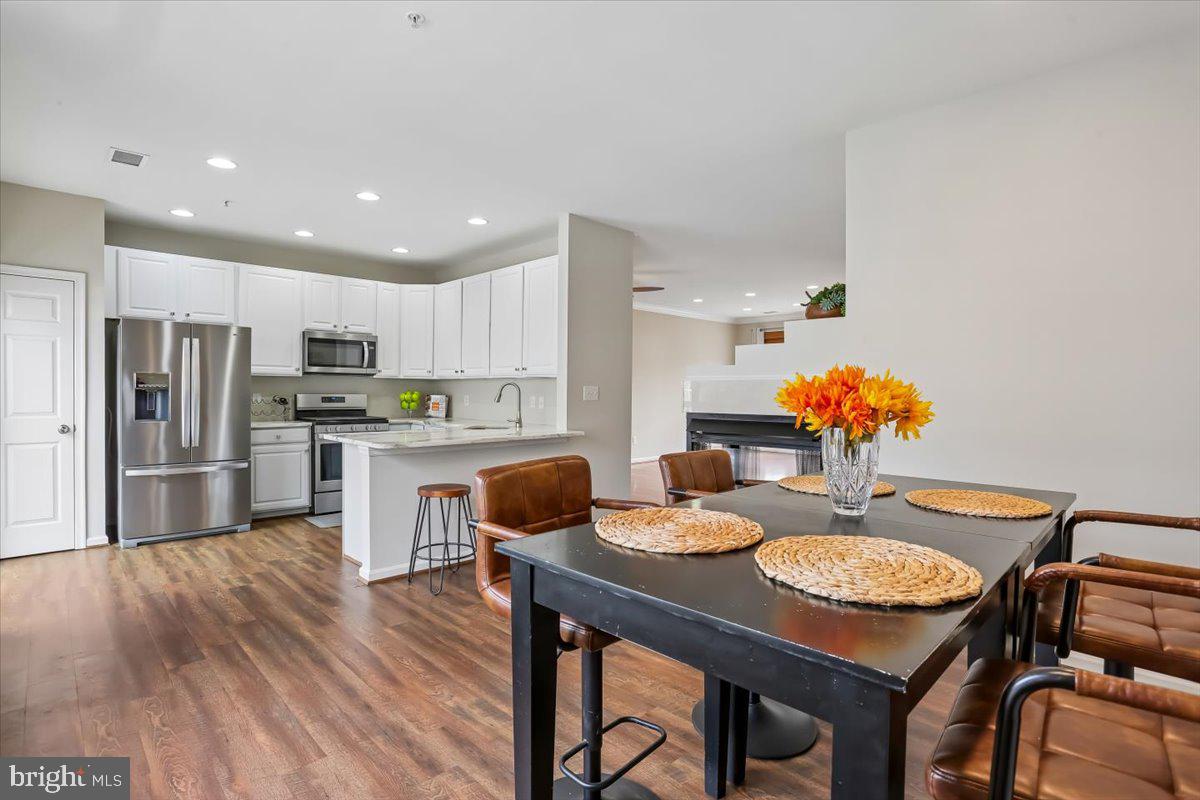 723 Main Street, Unit 723B Gaithersburg, MD 20878 - Photo 13 of 71 a kitchen with granite countertop kitchen island stainless steel appliances refrigerator dining table and chairs