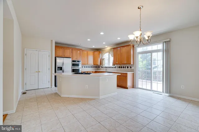 a kitchen with stainless steel appliances granite countertop a refrigerator a sink dishwasher and white cabinets with wooden floor