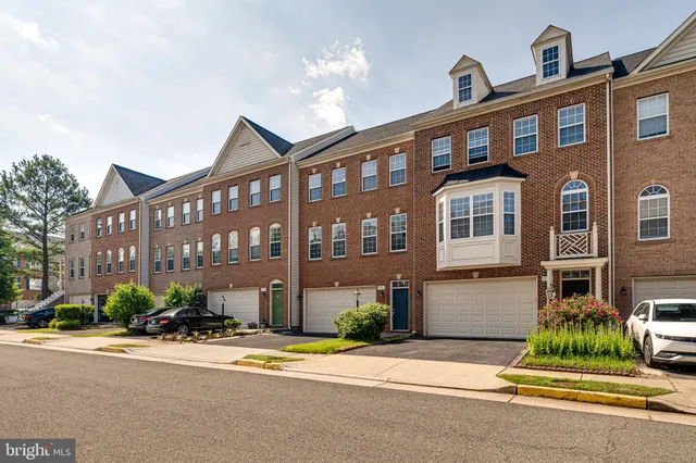a front view of a building with a garden and plants