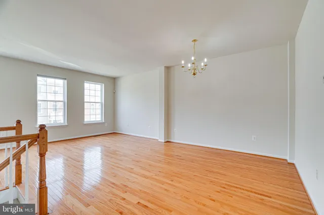 a view of a room with wooden floor and chandelier