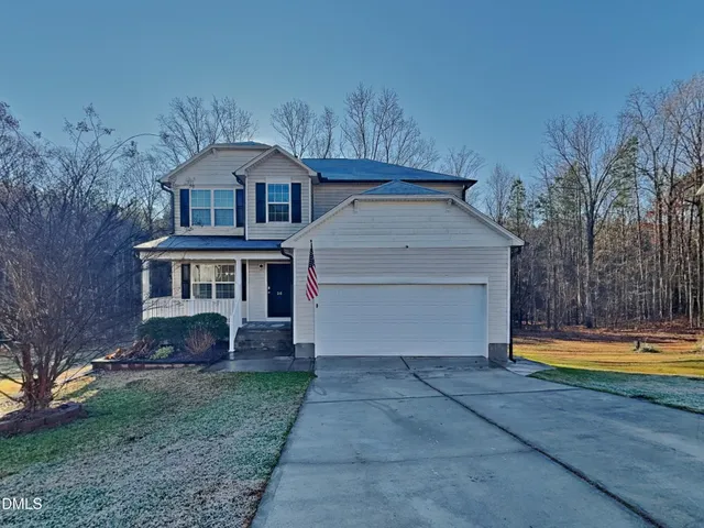 a front view of a house with a yard and trees