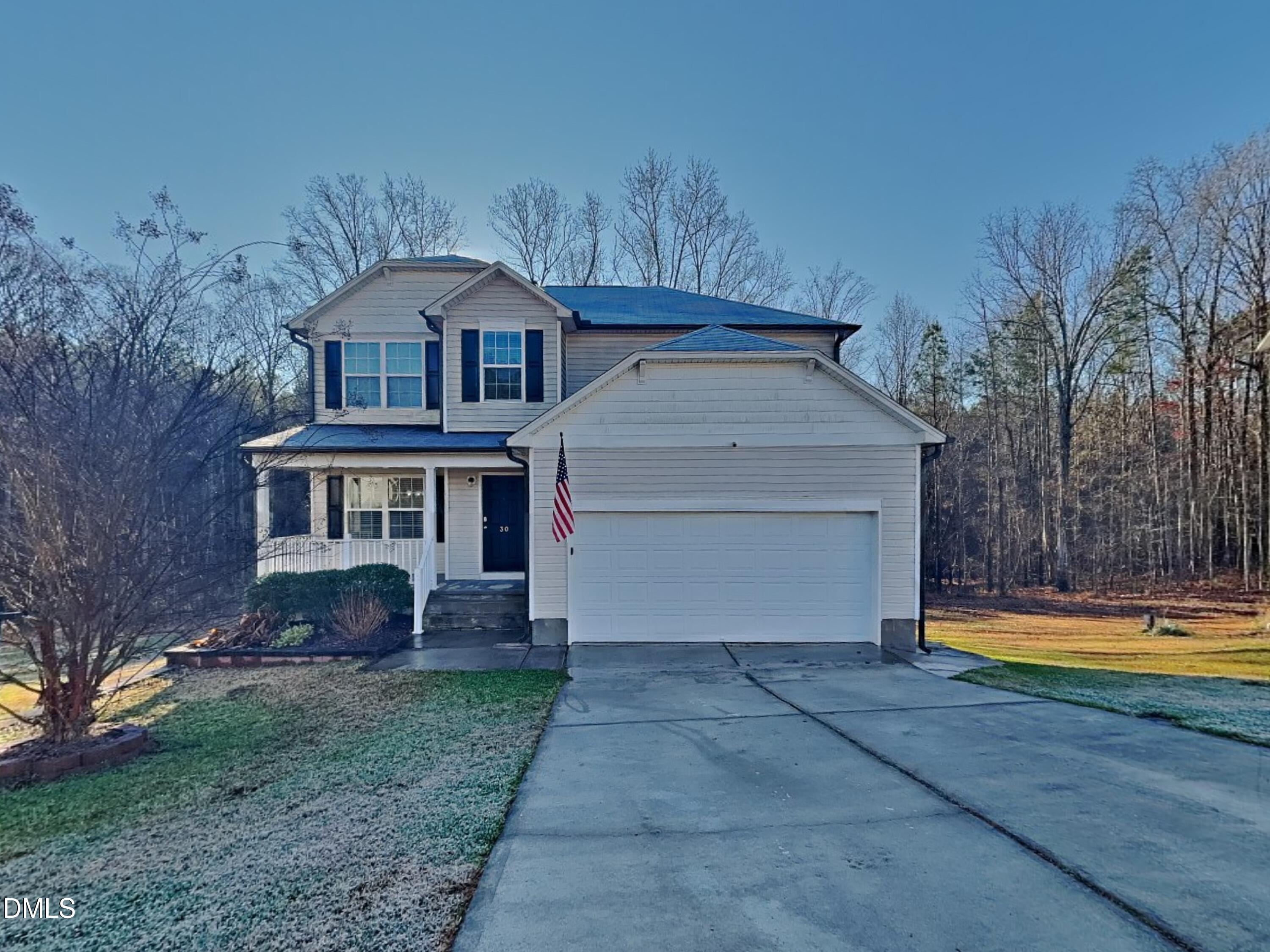 a front view of a house with a yard and trees