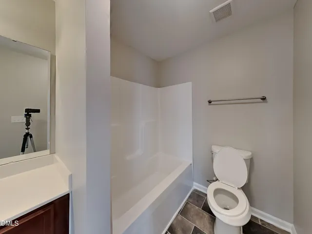 a white toilet sitting next to a bathroom sink