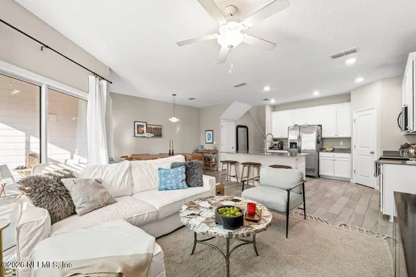 a living room with furniture and kitchen view