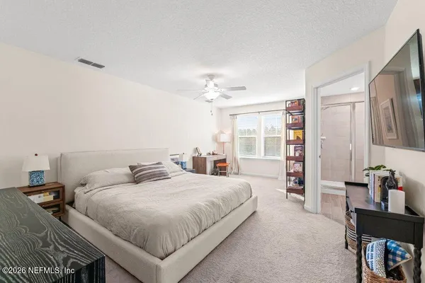 a large bedroom with bed and a chandelier