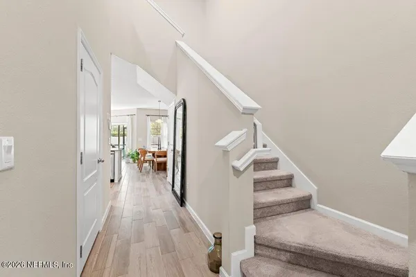 a view of a hallway with wooden floor and staircase