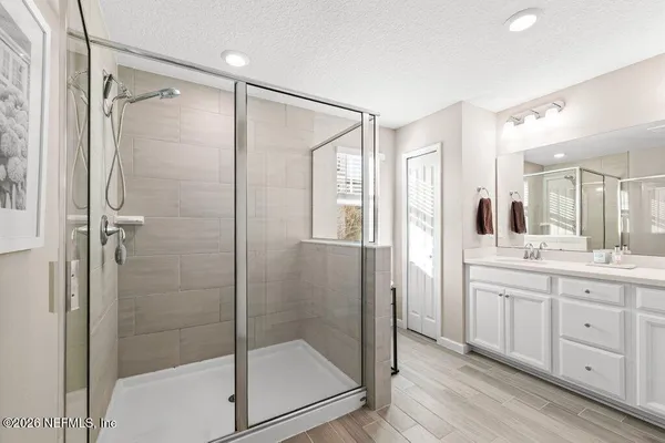 a bathroom with a shower sink and mirror