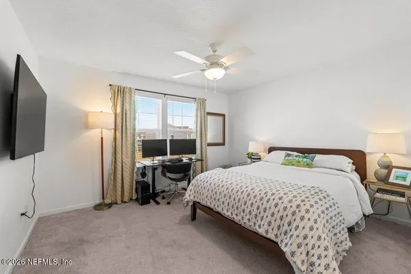 a bedroom with a bed and a flat tv screen on the dresser