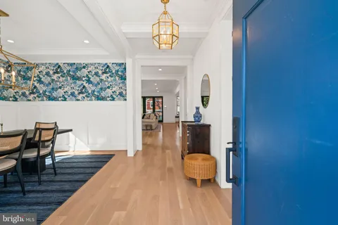 a dining room with furniture a chandelier and wooden floor