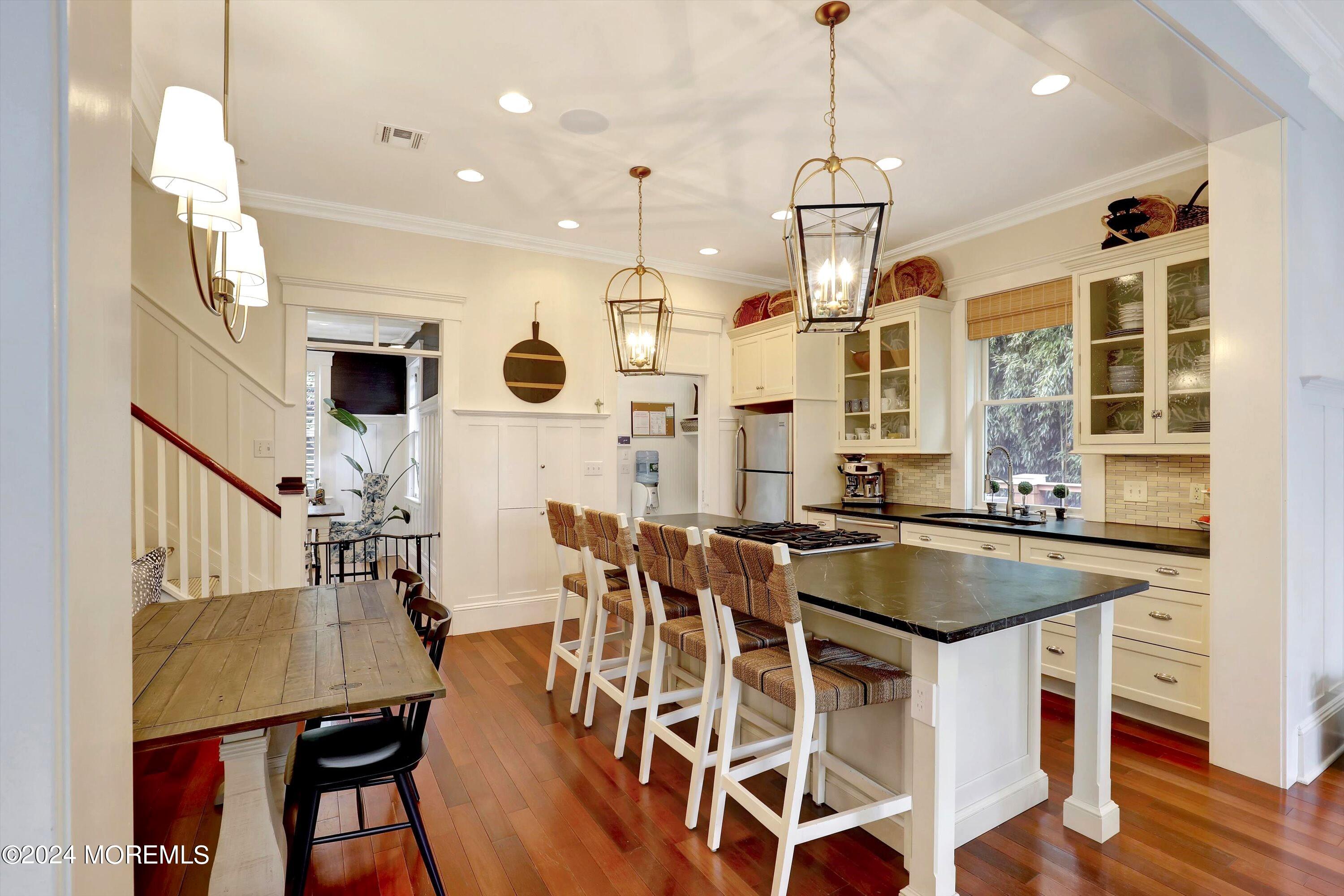 18 Hubbard Park Red Bank, NJ 07701 - Photo 15 of 54 a kitchen with stainless steel appliances kitchen island granite countertop a stove a refrigerator a oven a dining table and chairs with wooden floor