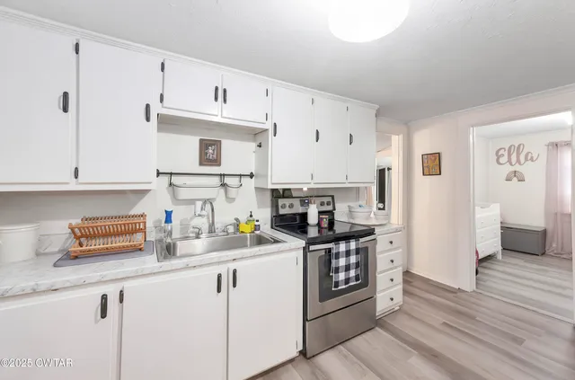 a kitchen with stainless steel appliances a sink stove refrigerator and cabinets