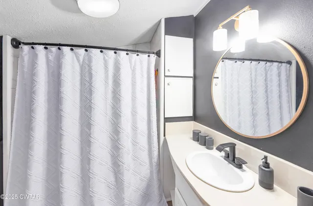 a bathroom with a sink vanity mirror and a mirror