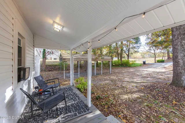 a backyard of a house with fountain table and chairs