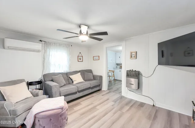 a living room with furniture a ceiling fan and a rug