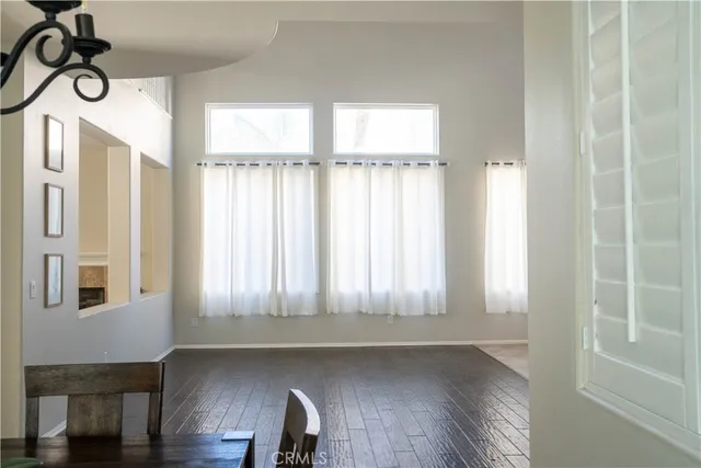 a view of a hallway with wooden floor and a living room