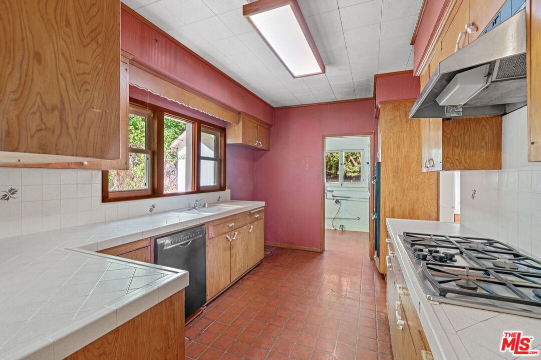 2429 North Commonwealth Avenue Los Angeles, CA 90027 - Photo 19 of 54 a kitchen with stainless steel appliances granite countertop a stove and a sink