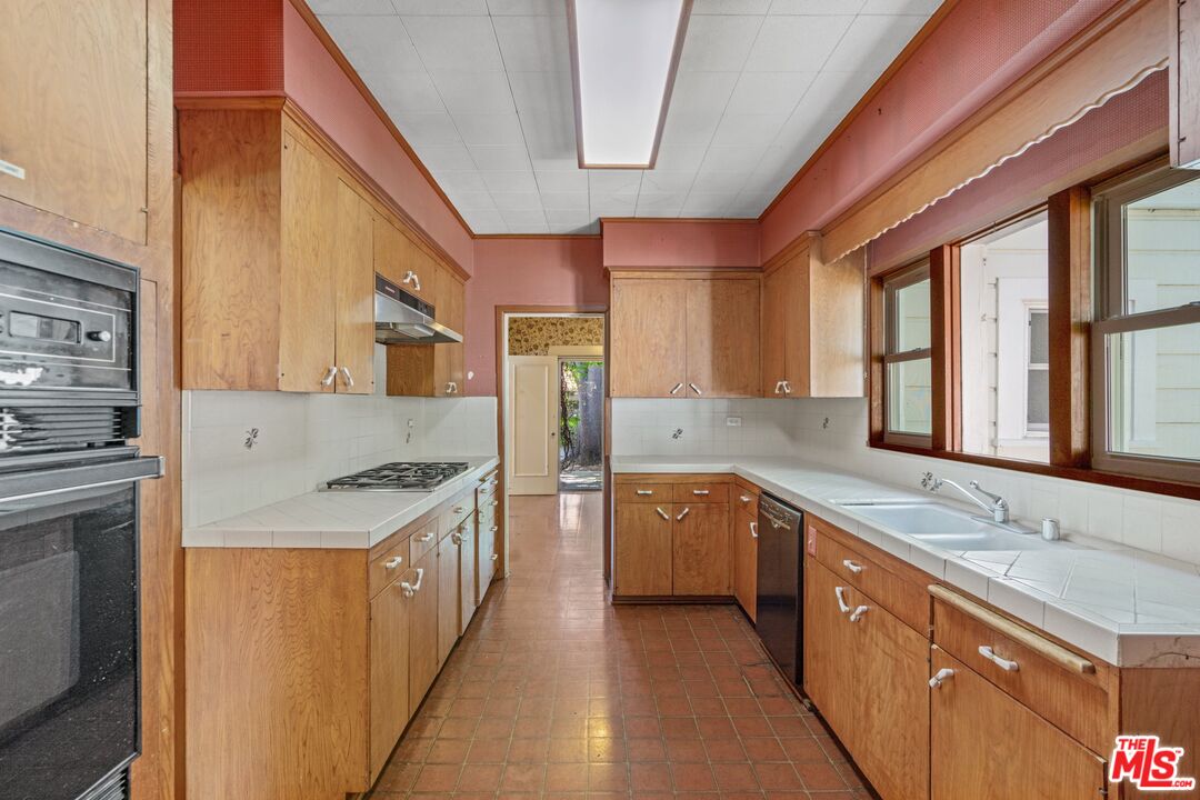 2429 North Commonwealth Avenue Los Angeles, CA 90027 - Photo 20 of 54 a kitchen with stainless steel appliances granite countertop a sink and a stove