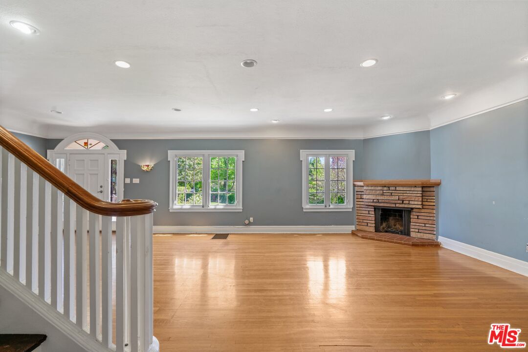 2429 North Commonwealth Avenue Los Angeles, CA 90027 - Photo 25 of 54 a view of empty room with fireplace and wooden floor