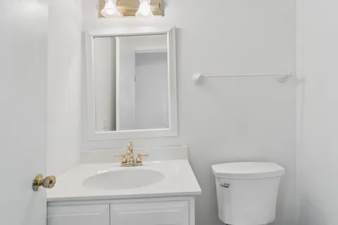a bathroom with a sink a toilet and a mirror