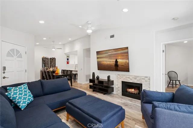a living room with furniture a flat screen tv and a fireplace