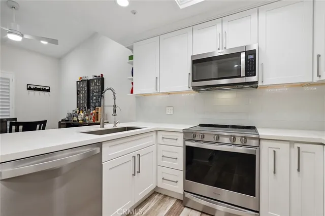 a kitchen with white cabinets and stainless steel appliances