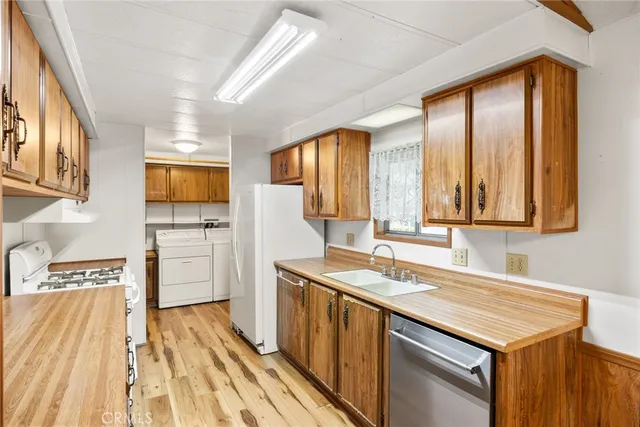 a kitchen with a sink appliances cabinets and a large window