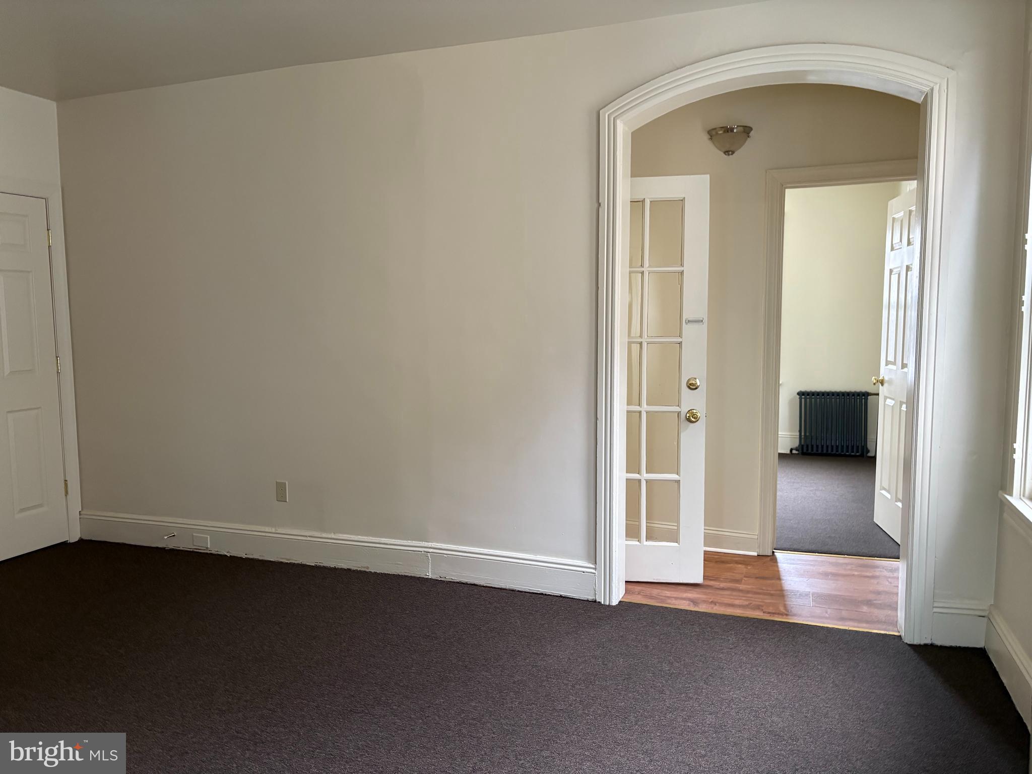 330 East Chestnut Street Coatesville, PA 19320 - Photo 4 of 17 an empty room with wooden floor and a bathroom view