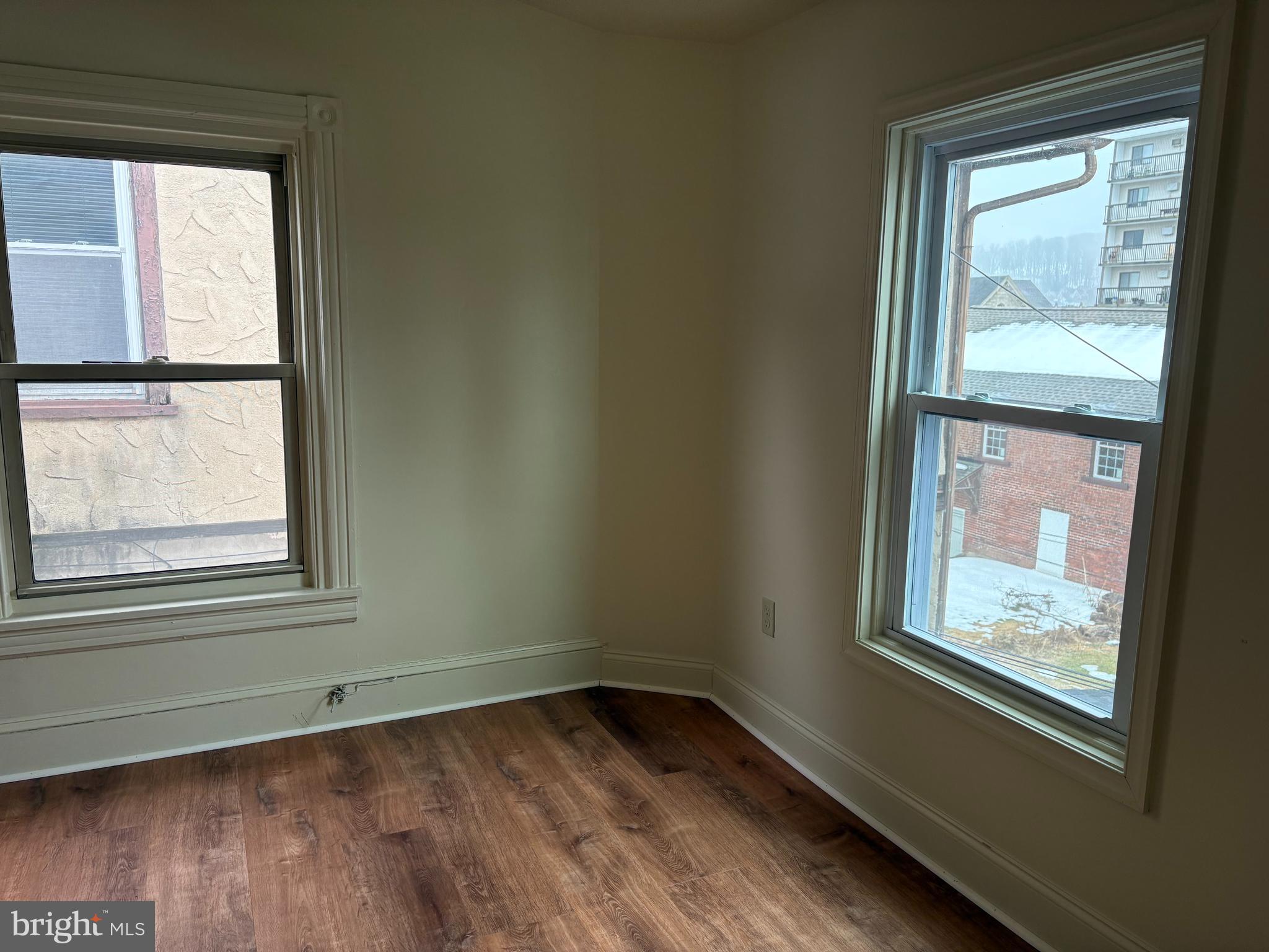 330 East Chestnut Street Coatesville, PA 19320 - Photo 6 of 17 a view of an empty room with wooden floor and a window