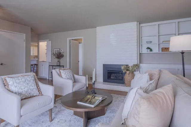 a living room with furniture a fireplace and a table